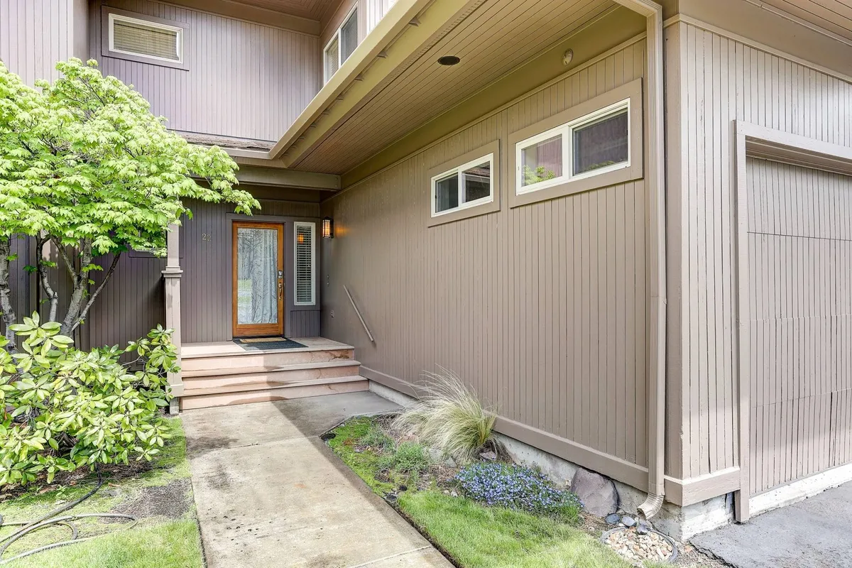 This image shows the welcoming front entrance of the property, highlighted by well-maintained landscaping, broad steps, and a cozy porch area that sets the tone for a refined yet inviting resort community.